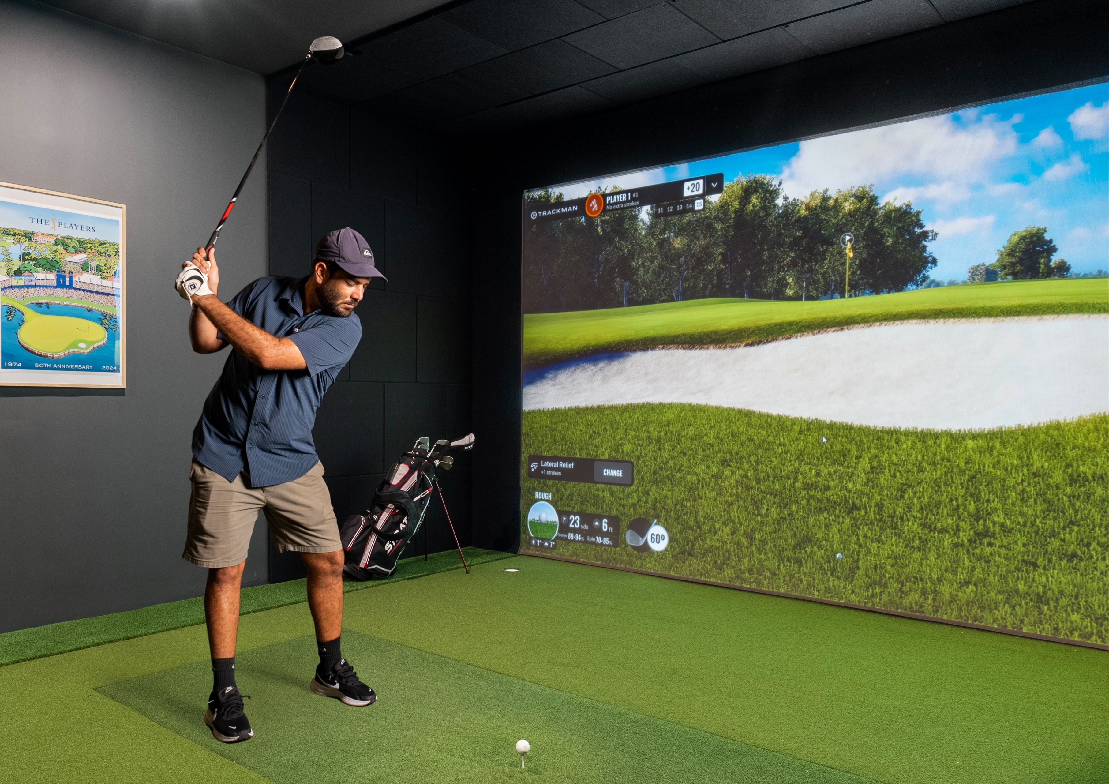 golfer swinging a club in state of the art golf simulator room