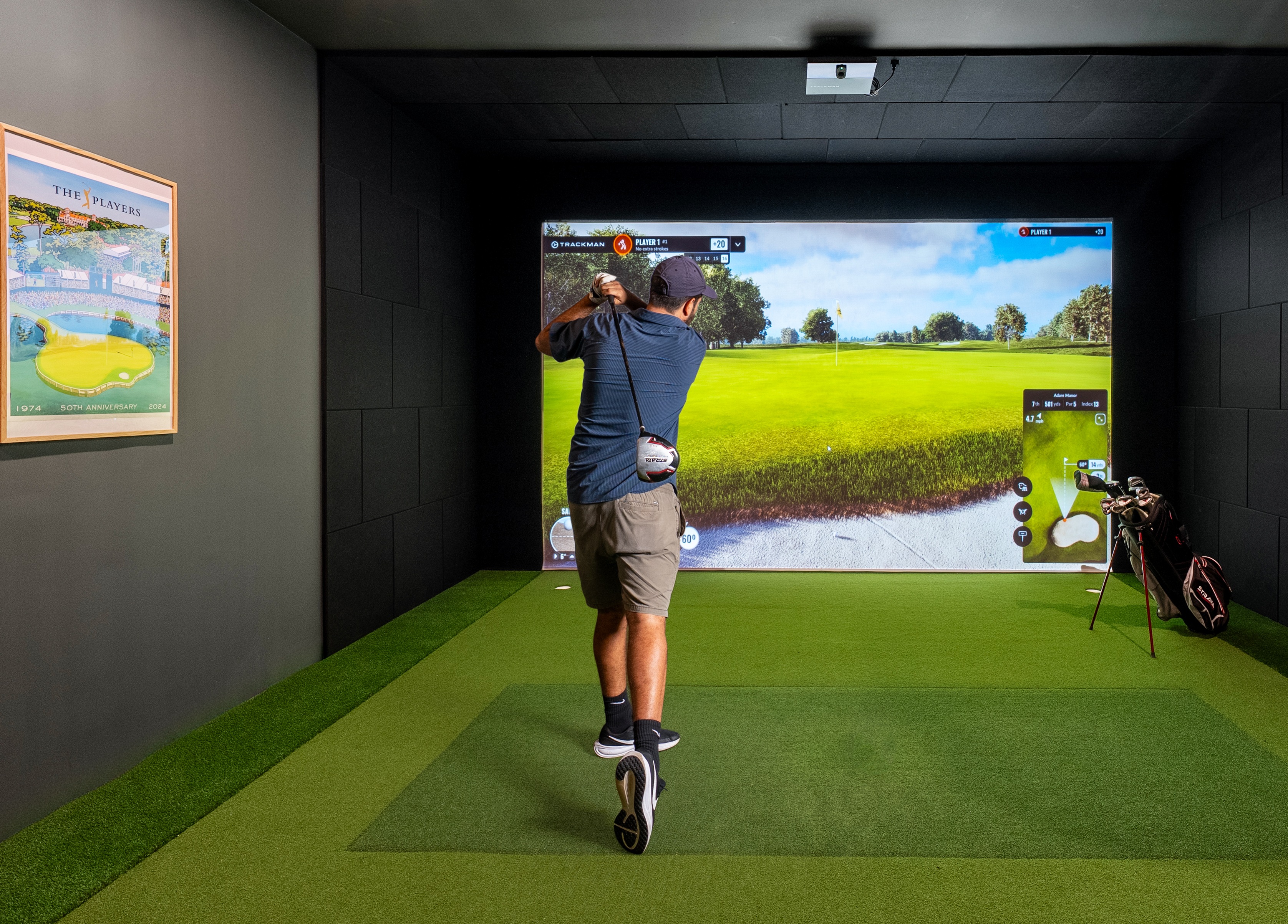 golfer swinging a club in state of the art golf simulator room